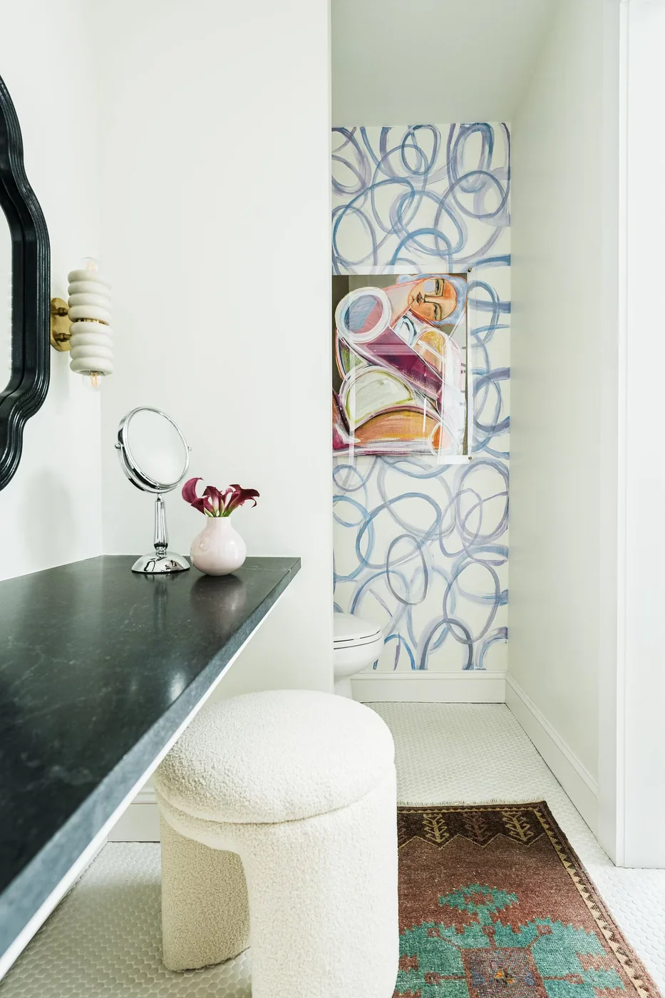 Blue calligraphic wall mural framing original artwork in a powder nook