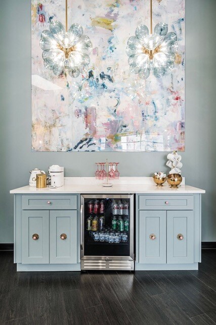 Commissioned abstract LUCiTE panel above a soft blue bar with flower pendant lights