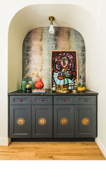 A designed niche styled by Summer Savin — original art above a charcoal cabinet with STANDOUT medallion hardware
